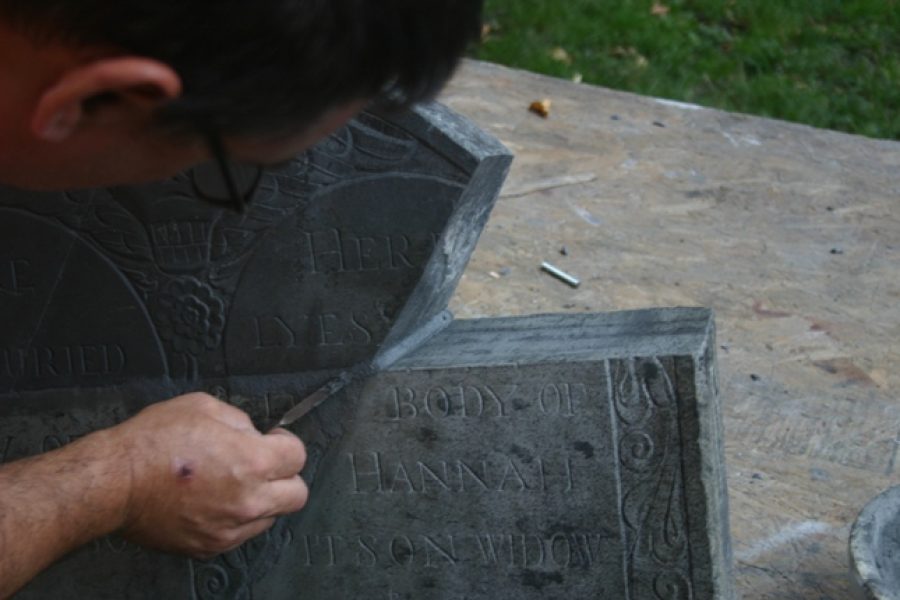 Conservator working on one of the gravestones